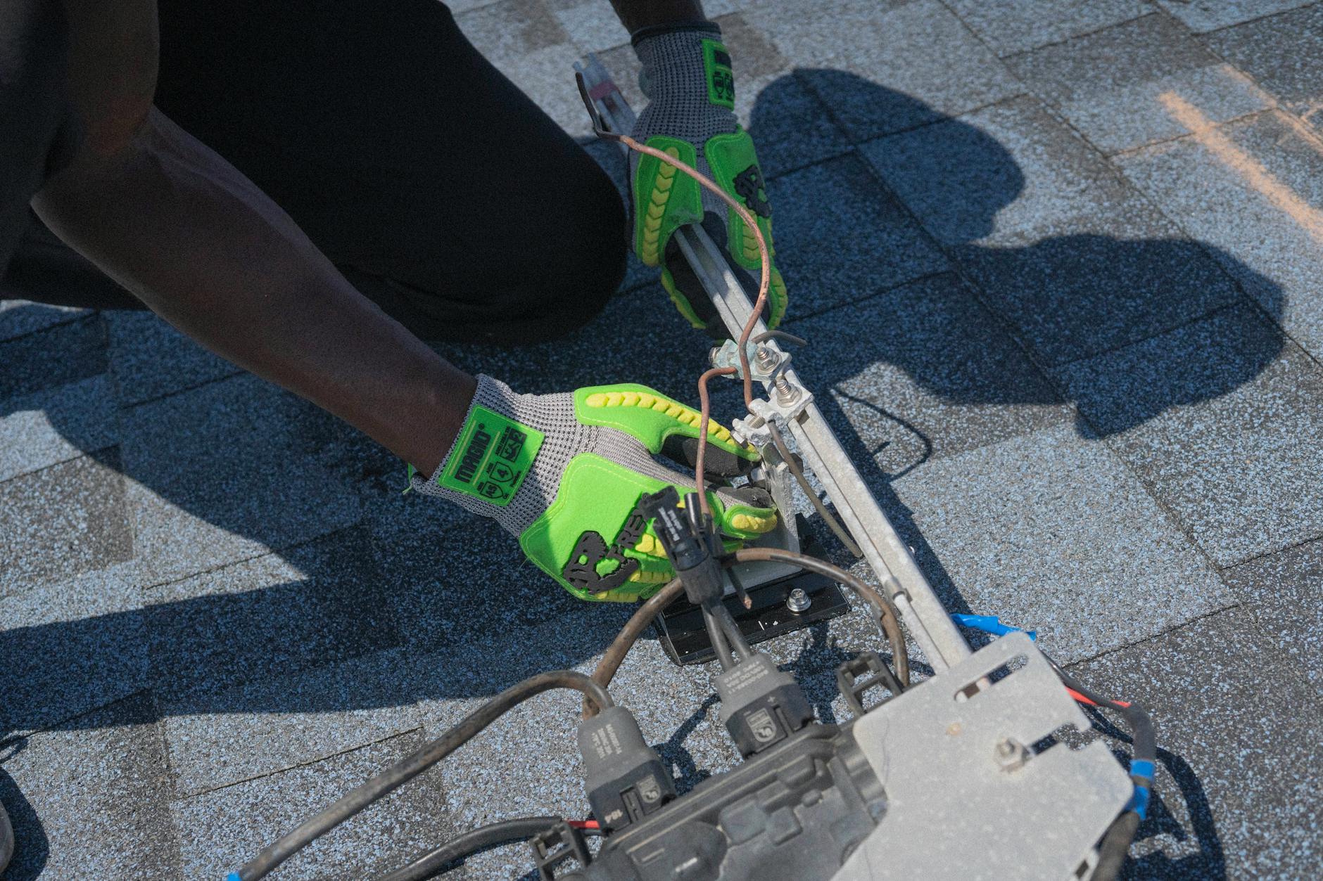 A GAF certified installer from Royal Peak Roofing meticulously inspecting an asphalt shingle roof on a Burlington home, ensuring quality and adherence to Massachusetts building code.